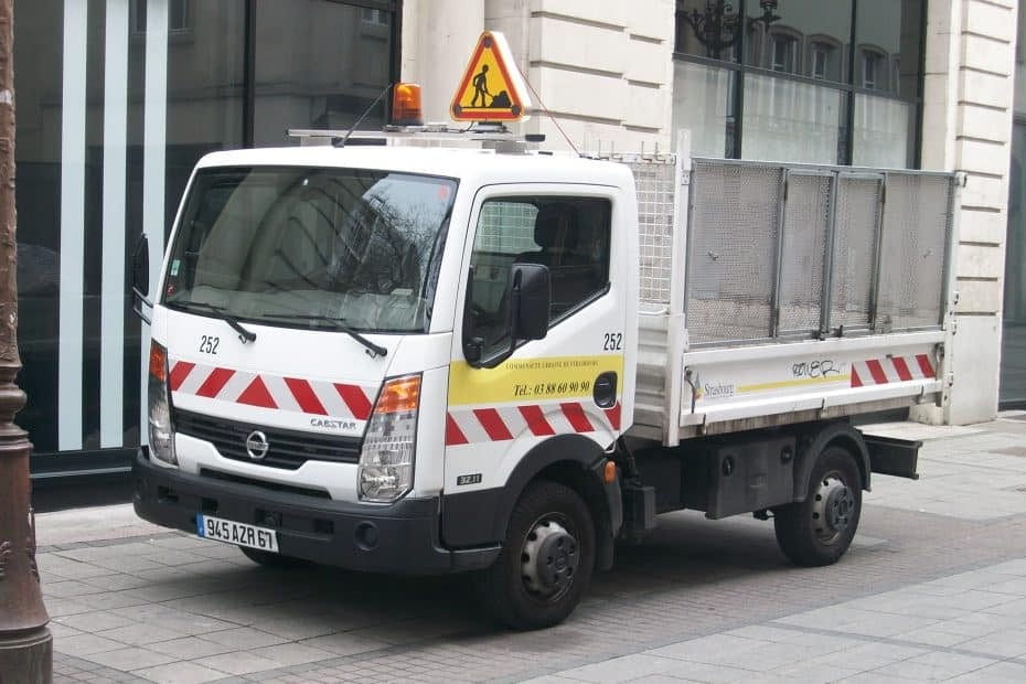 A white and yellow truck parked on the side of a street.