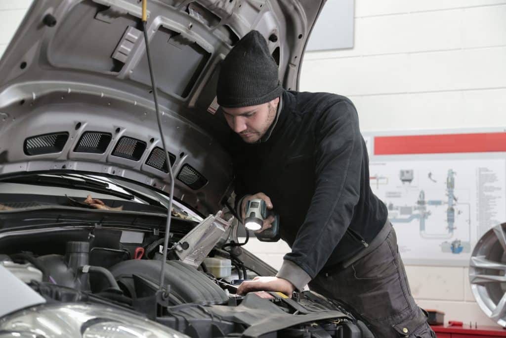 A man working on the engine of a car.