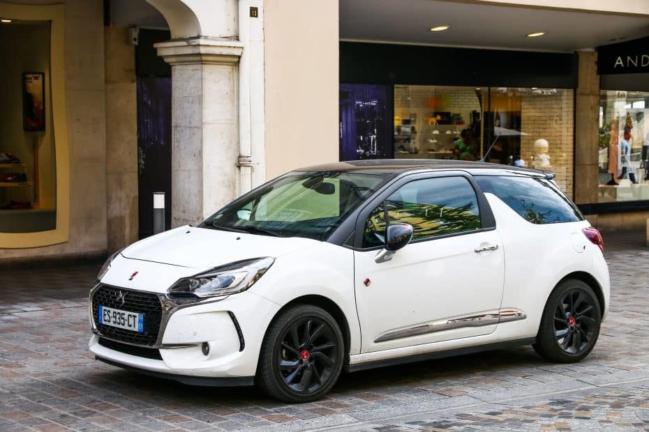 The white peugeot dci is parked on a cobblestone street.