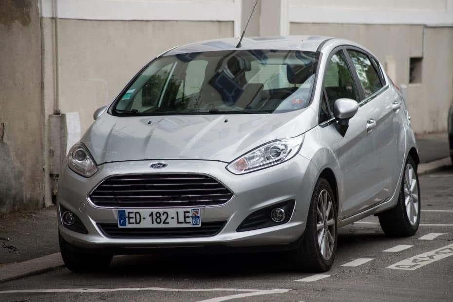 A silver ford fiesta parked on the side of the street.