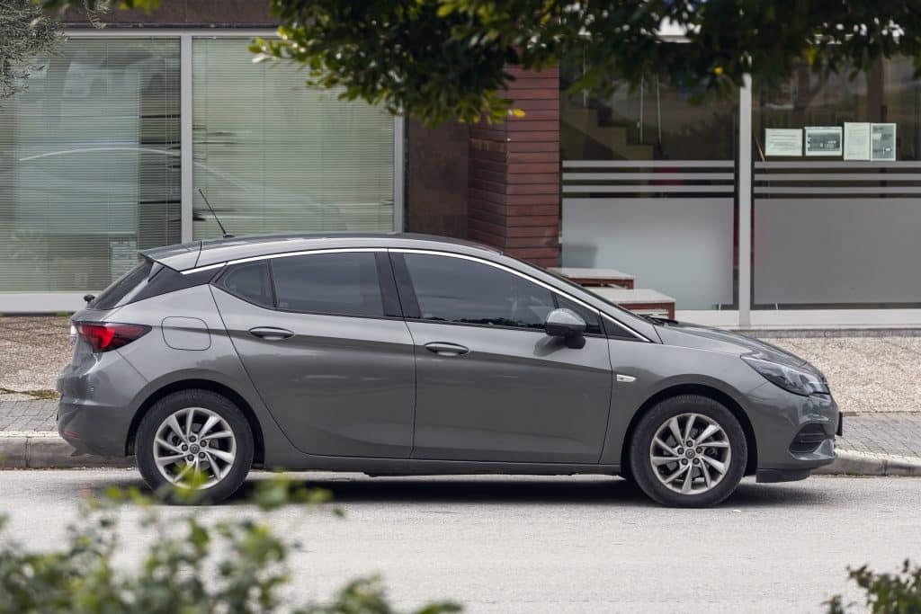 A grey opel astra parked in front of a building.
