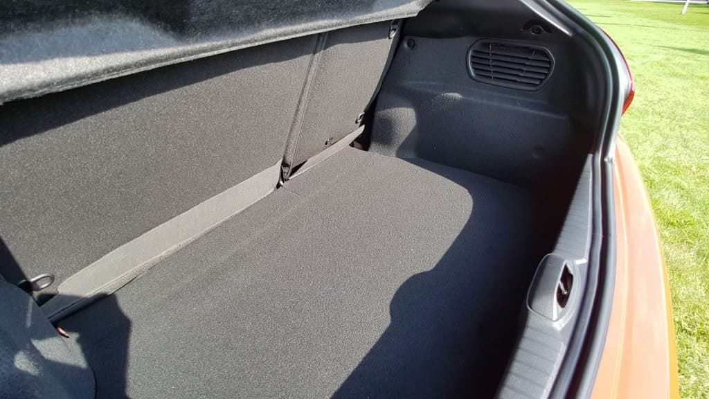 The trunk of an orange car with a black interior.
