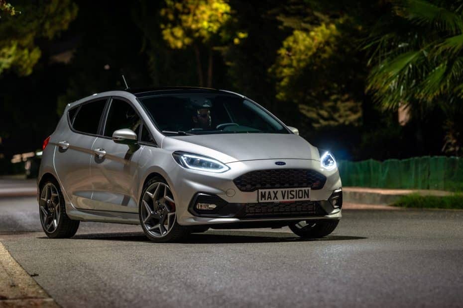 The 2019 ford fiesta st is driving down a street at night.